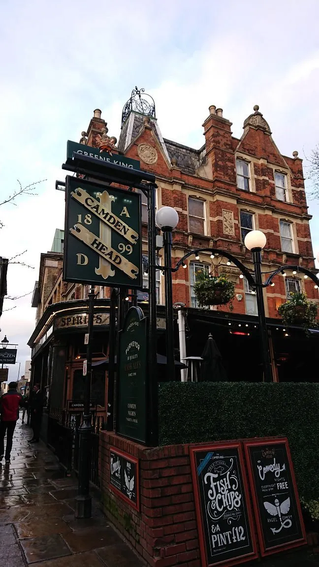 Exterior of a traditional pub with signs and brick facade.