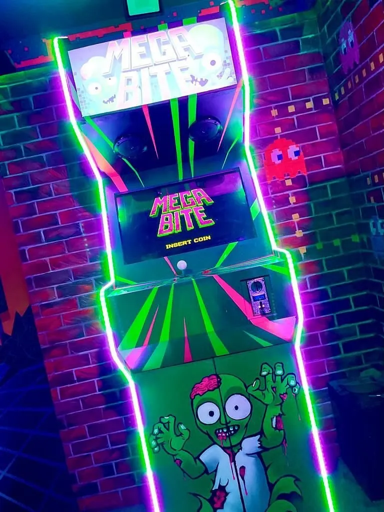 Retro arcade machine with neon lights and zombie design.