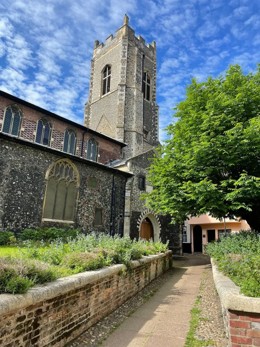 Historic stone church with tower and garden path