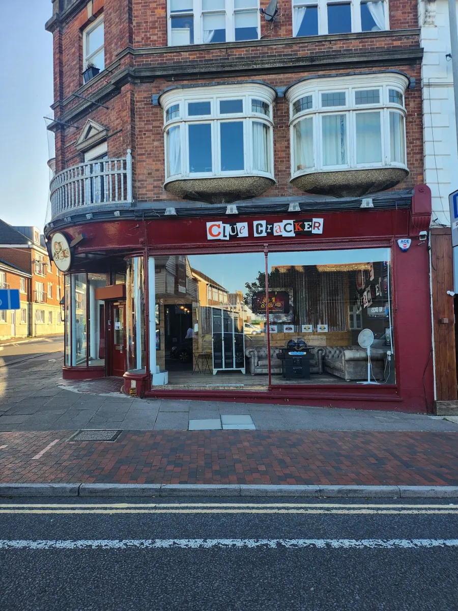Street view of a brick building with a shop named Clue Cracker.