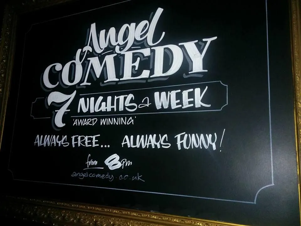 Chalkboard sign for Angel Comedy, 7 nights a week.