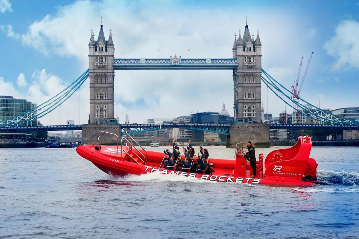 Red speedboat on the Thames with Tower Bridge in background