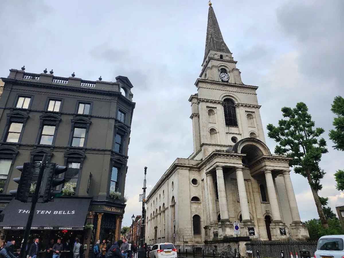 Historic church with clock tower next to a building.