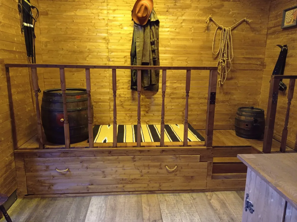 Rustic wooden room with barrels and western decor.