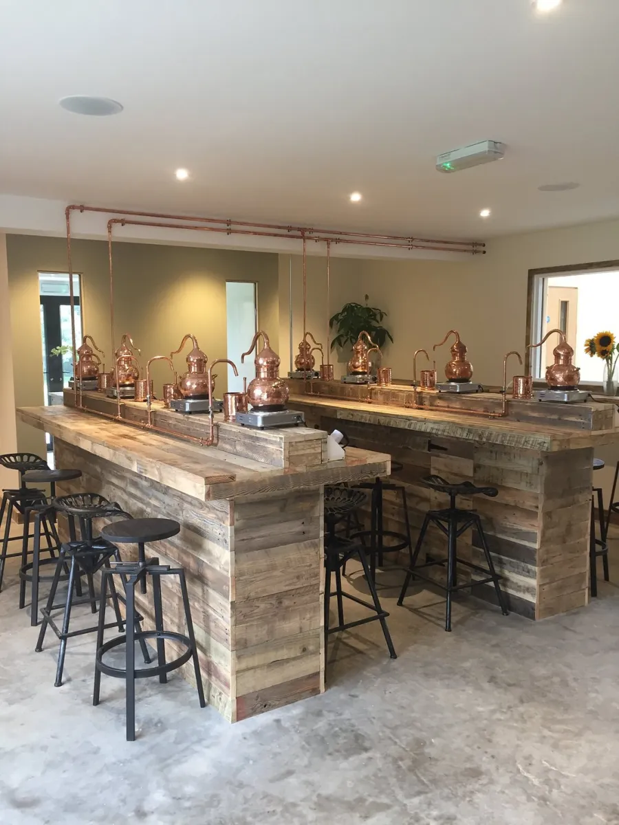 Wooden bar with copper stills and stools