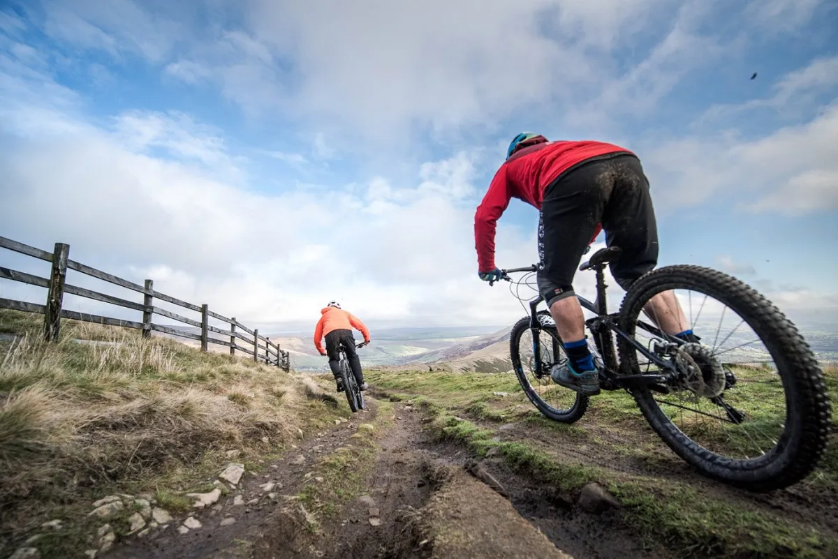 Two cyclists riding on a mountain trail.