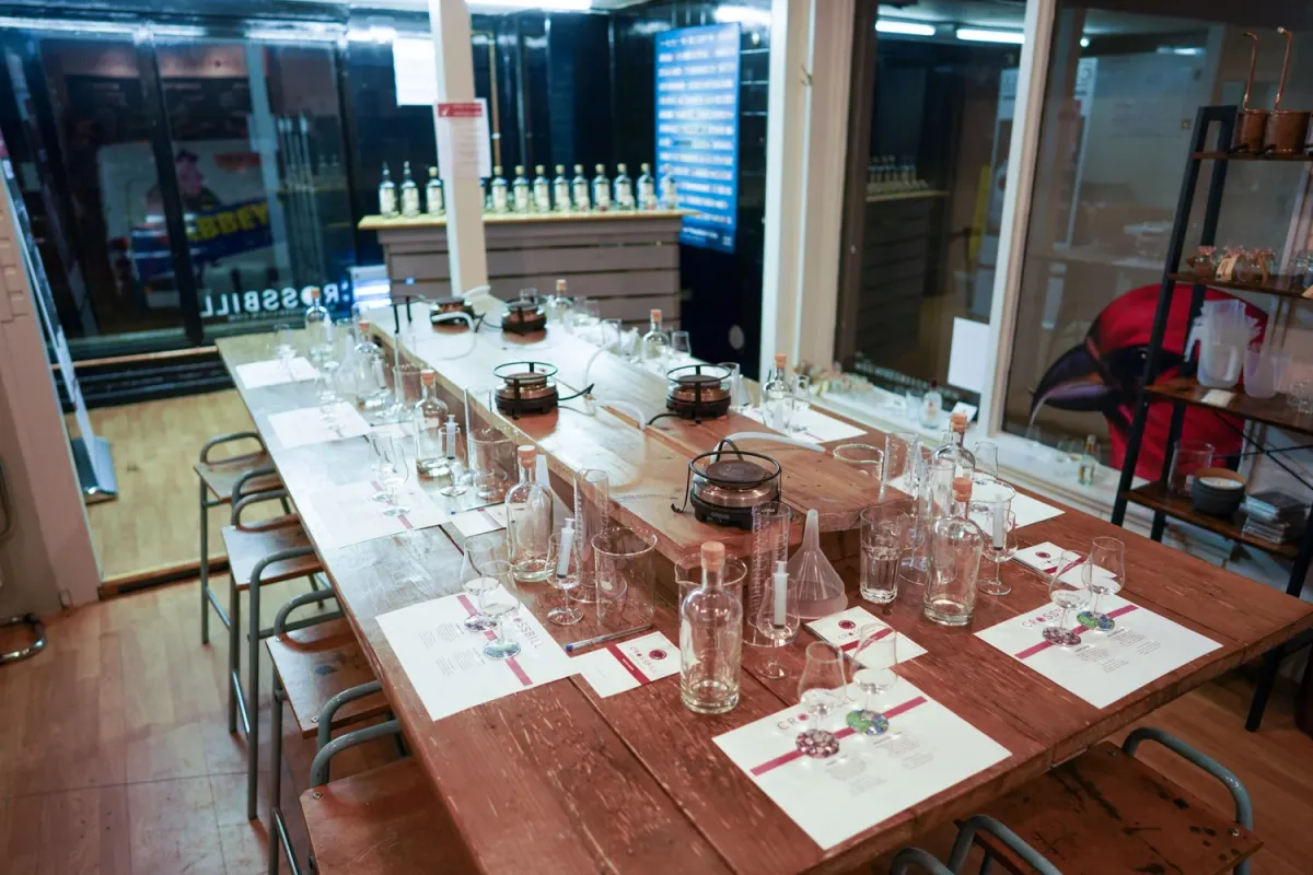 Wooden table set up for a tasting event with glasses and bottles.