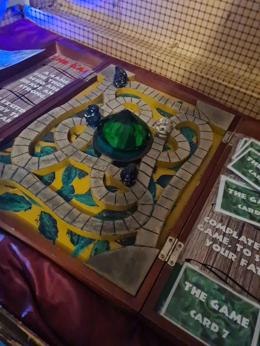 Board game with a green gem centerpiece and stone path.