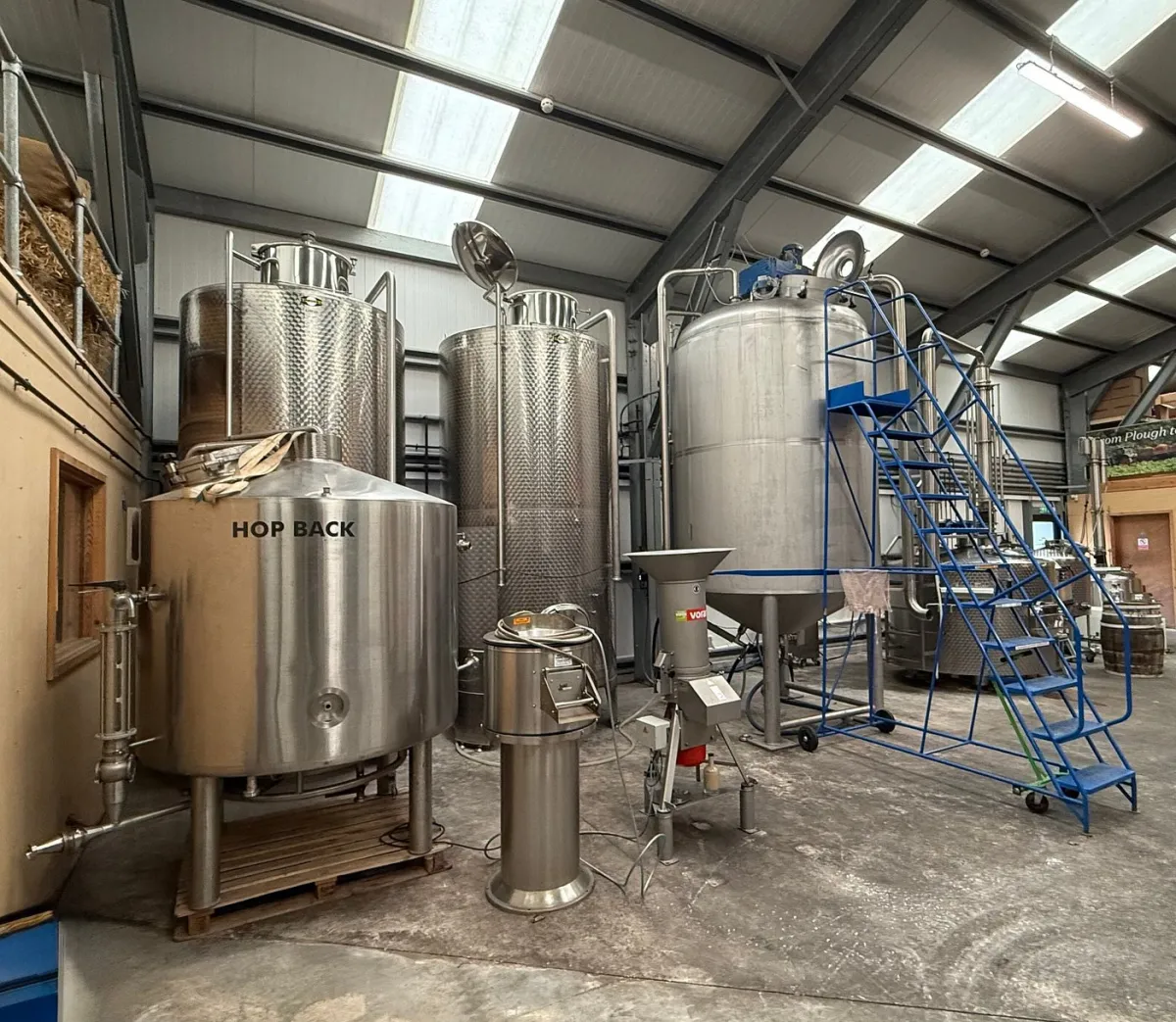 Interior of a brewery with large metal tanks.