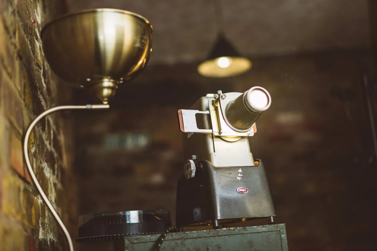 Vintage film projector with brick wall background.
