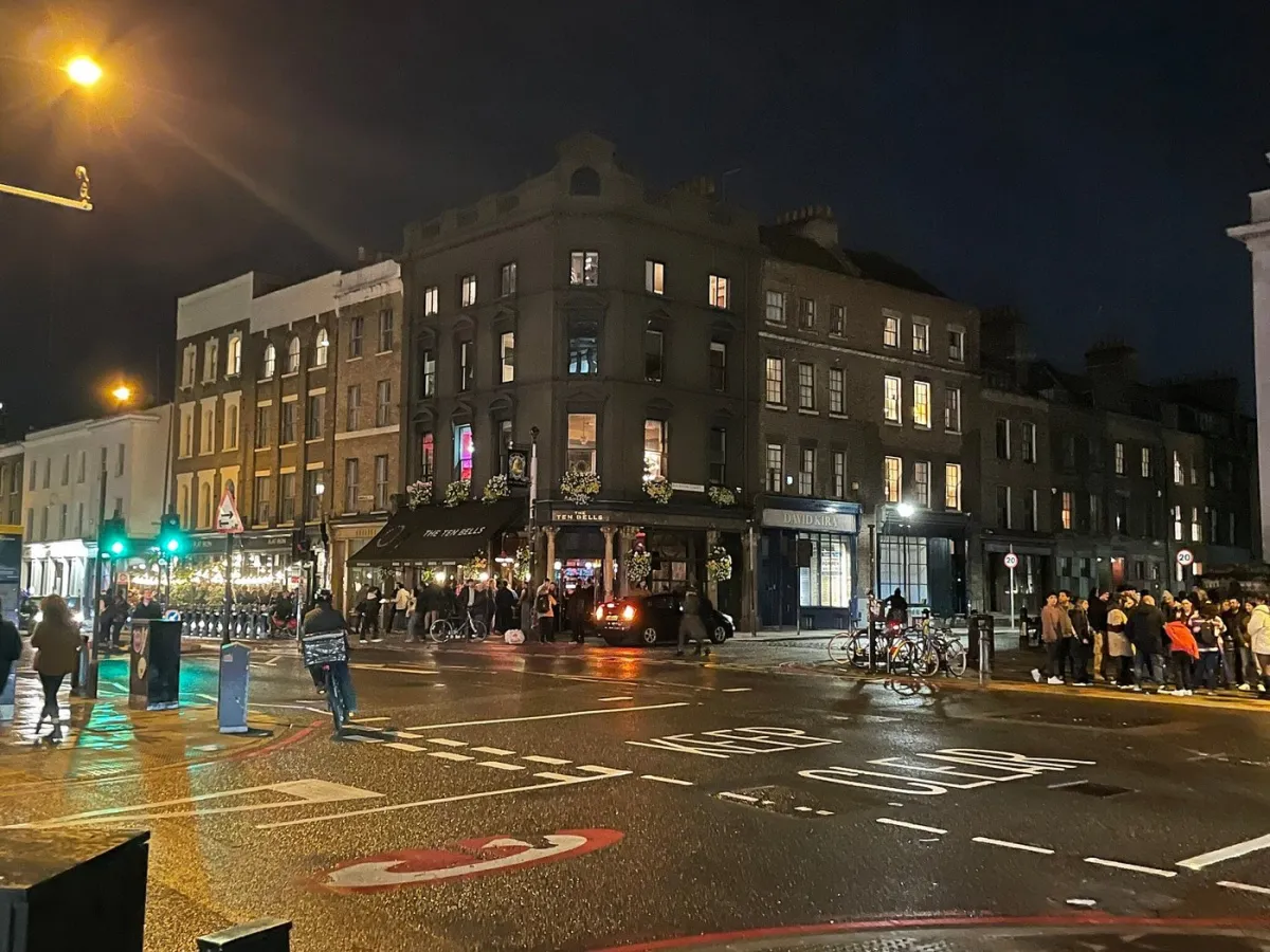 Night street scene with people and lit buildings