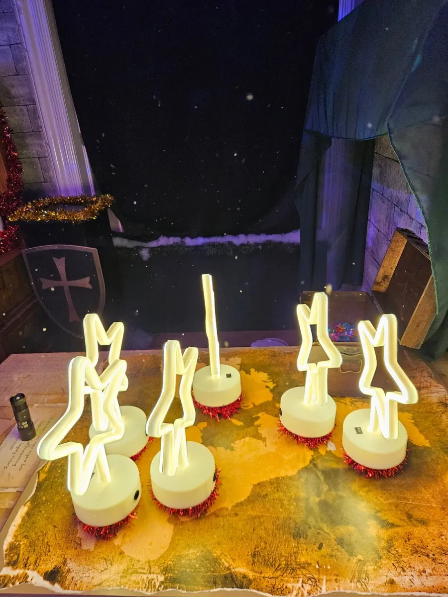 Neon star lights on a table with festive decorations.
