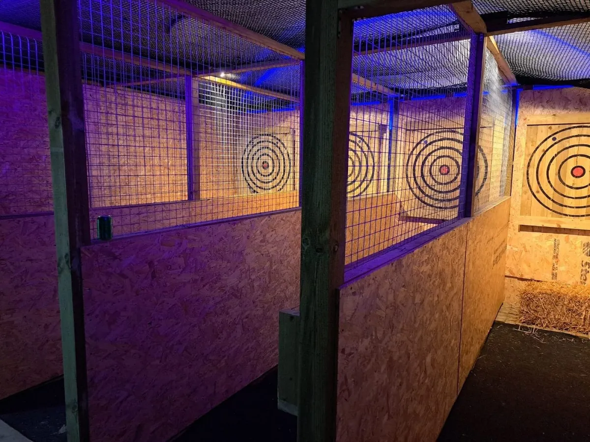 Indoor axe throwing lanes with targets.