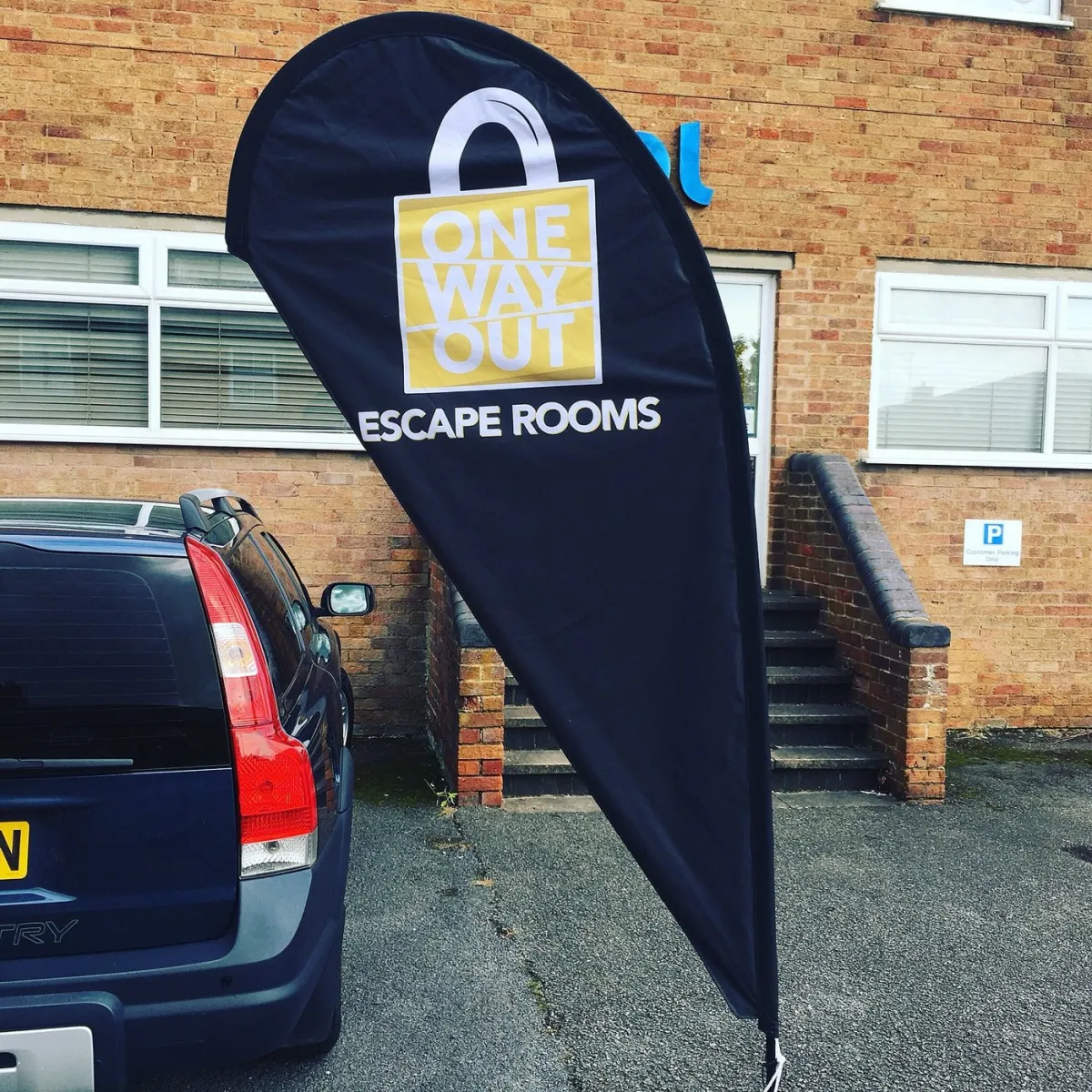 Sign for One Way Out Escape Rooms outside a building.