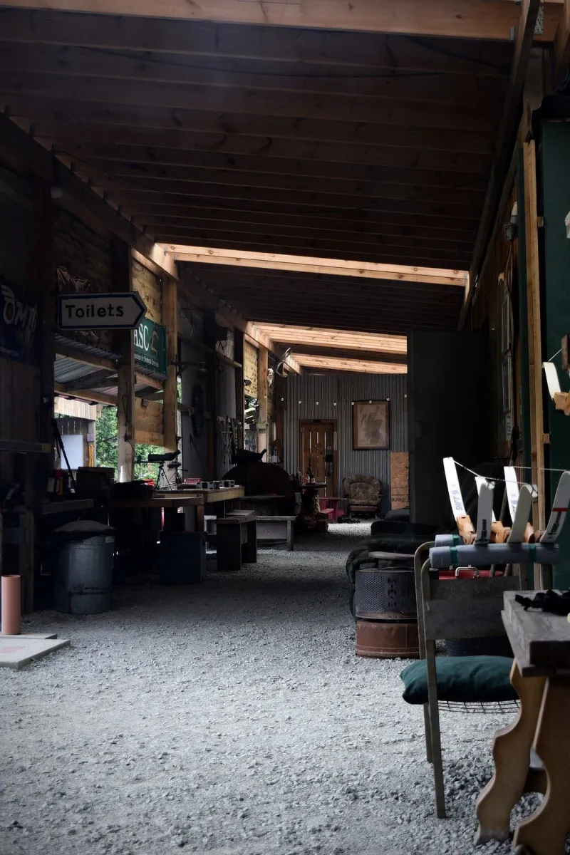 Covered outdoor area with various items and a sign pointing to toilets.