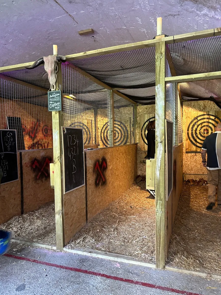 Axe throwing lanes with targets and wooden dividers.