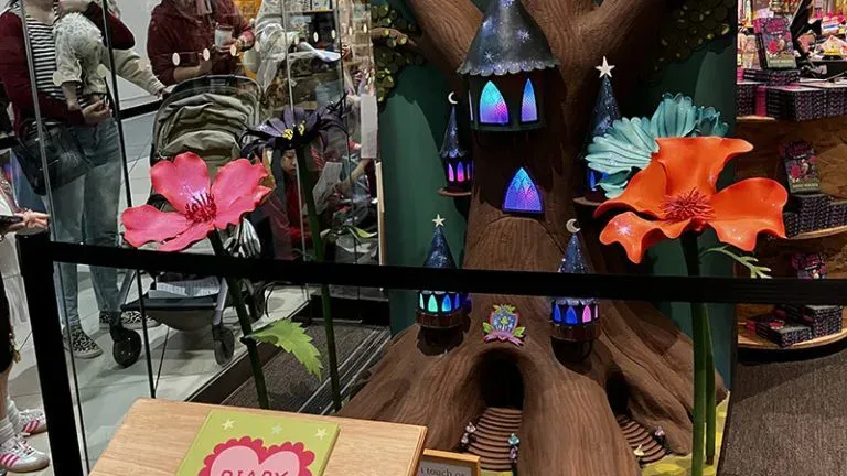 Colorful fairy house display with large flowers.