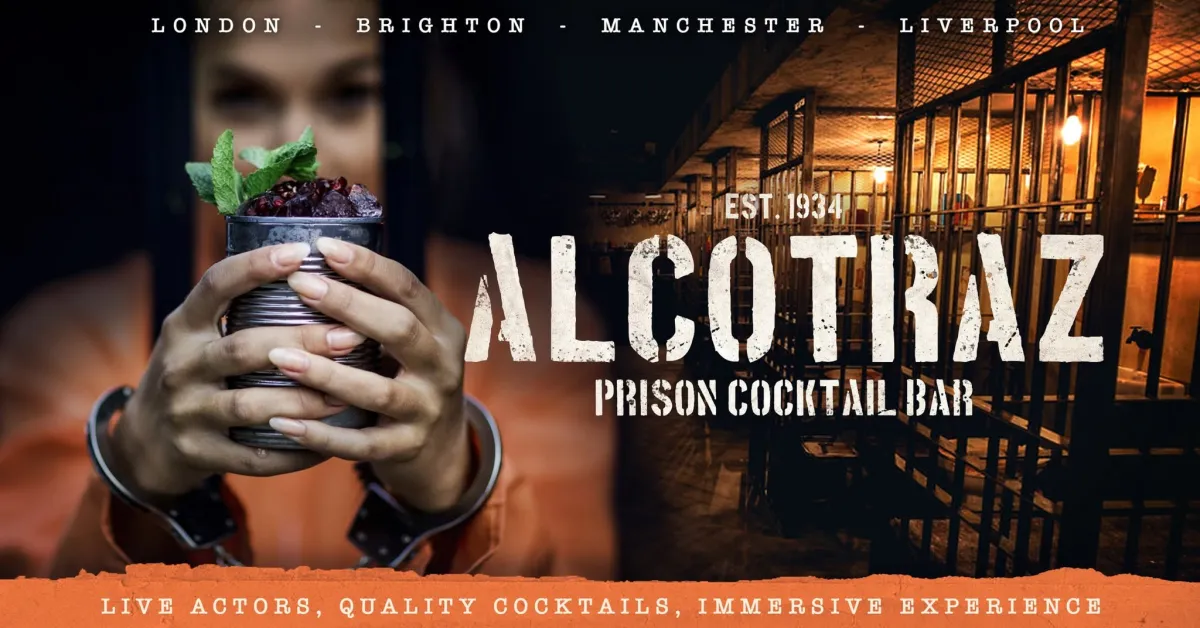 Person holding a cocktail in a jail-themed bar.