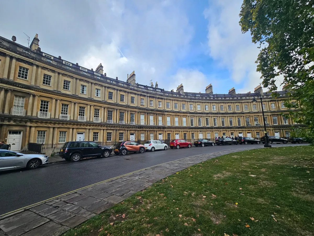 Curved historic building with parked cars