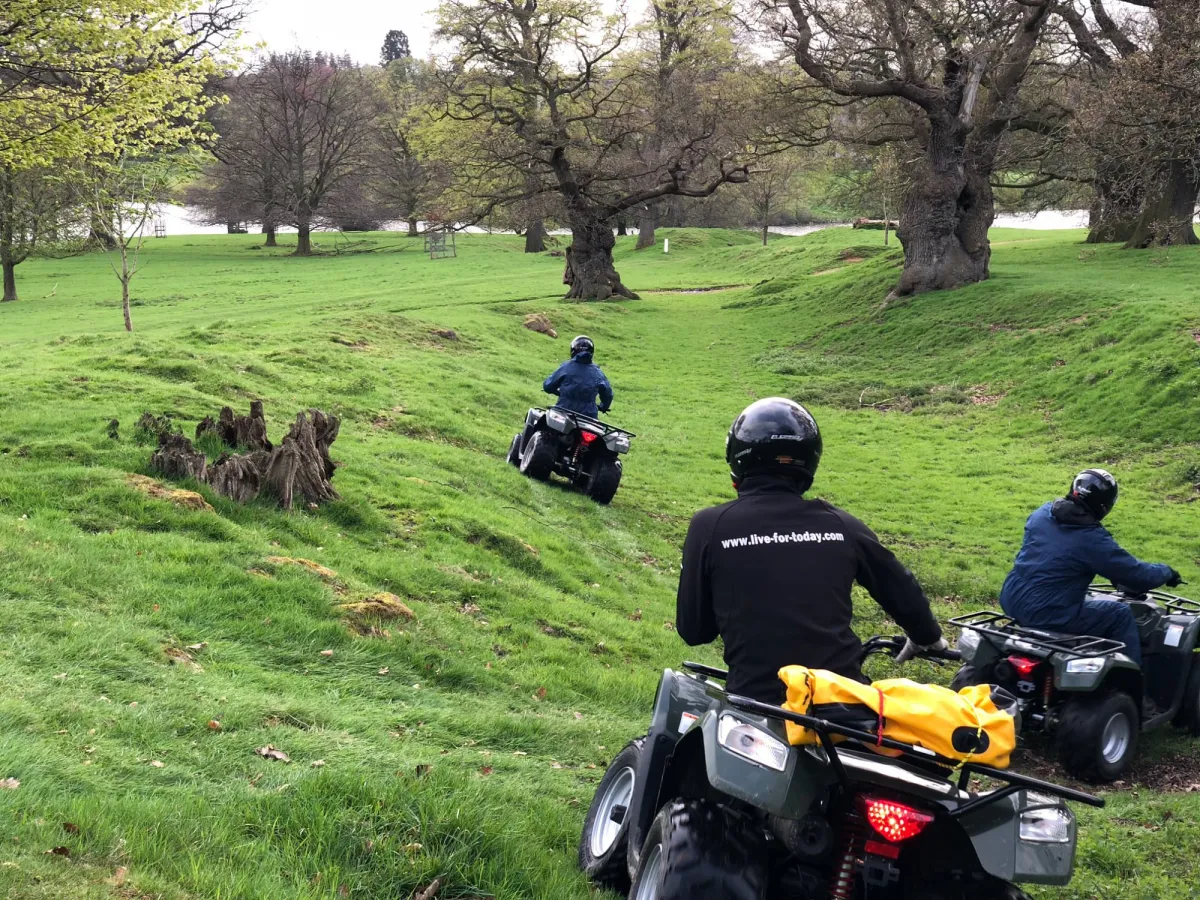 People riding quad bikes on a grassy field