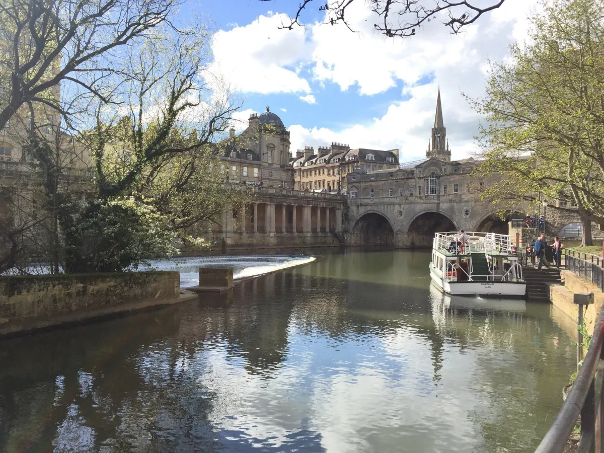 River with historic bridge and buildings in the background.