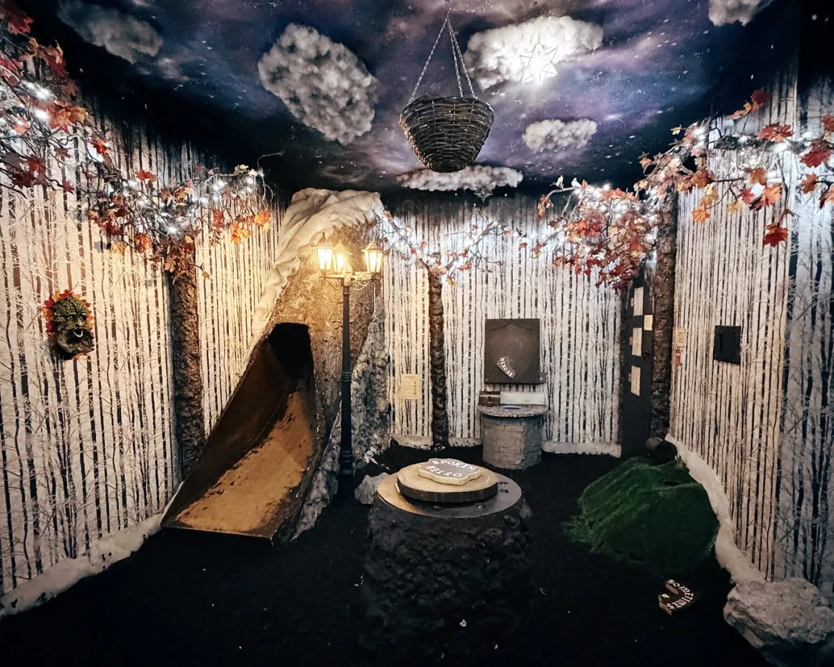 Fantasy-themed room with forest decor and slide.