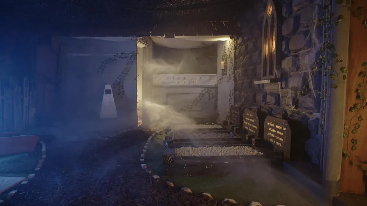 Spooky graveyard scene with fog and tombstones.
