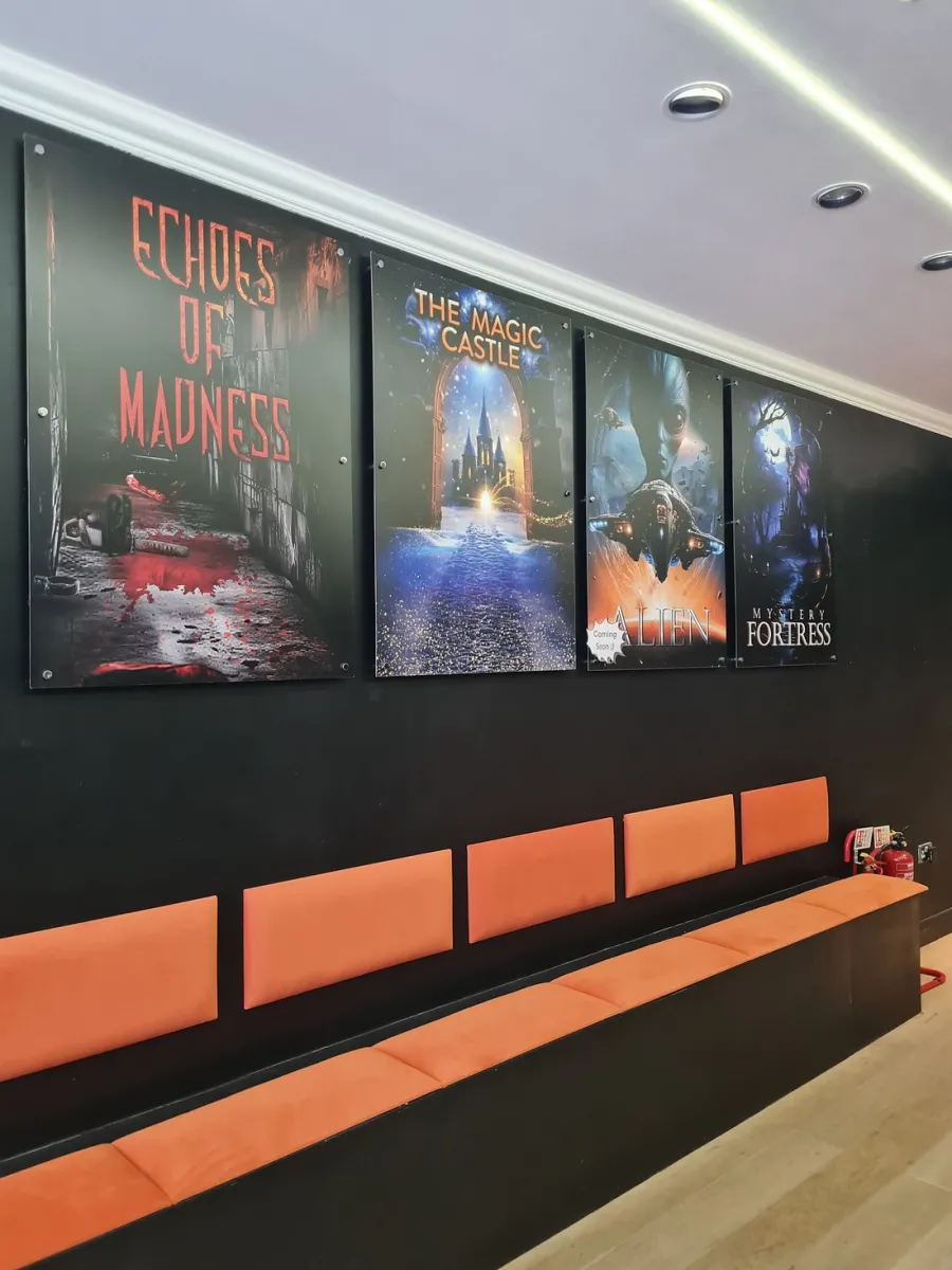 Wall with movie posters above orange bench seating.
