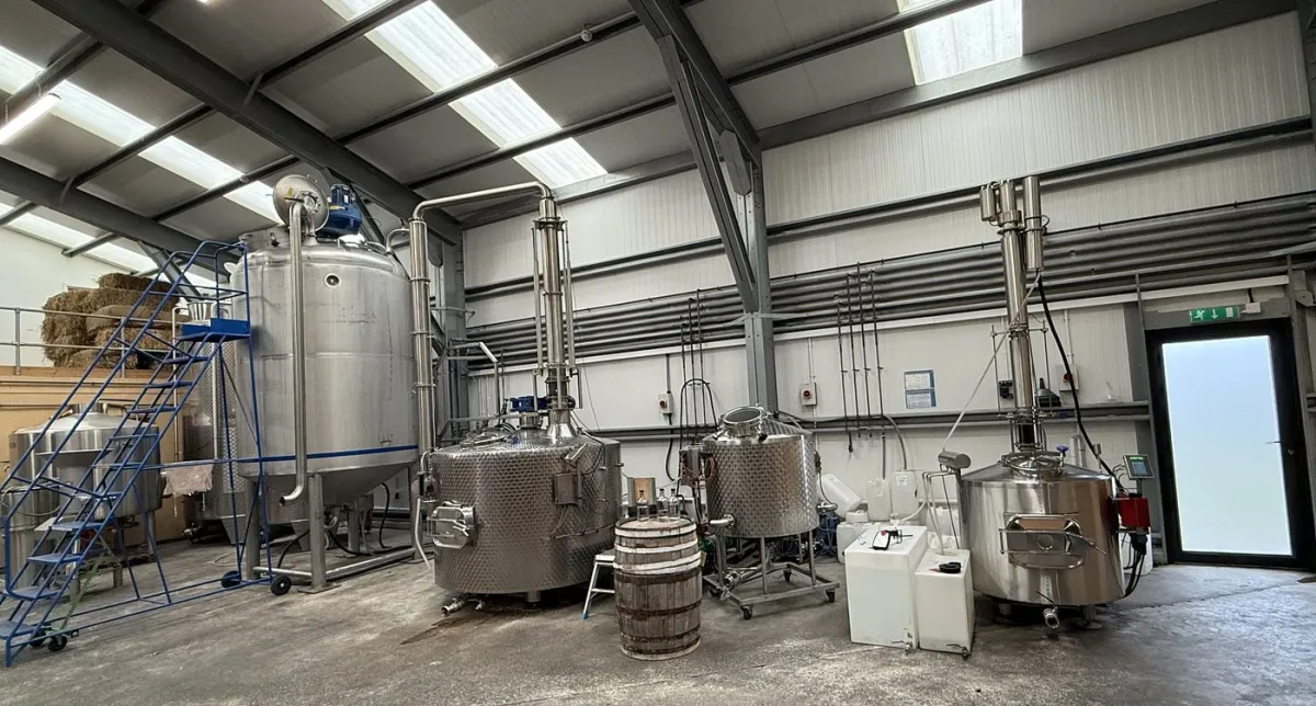 Interior of a distillery with large metal tanks.