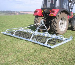 Ritchie 4m Manual Folding Grass Harrow attached to a tractor.