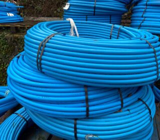 Large rolls / coils of blue MDPE water pipe.