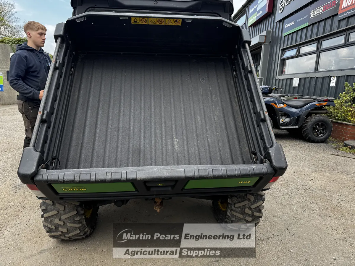 Jon Deere Gator 4x4 UTV with cargo bed tipped